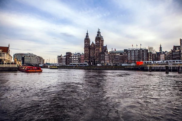 Amsterdam, Nederländerna - 15 januari 2016: Berömda byggnader av Amsterdam city centre närbild på sun ställa in tiden. Generalen landskap vy. Amsterdam - Nederländerna. — Stockfoto