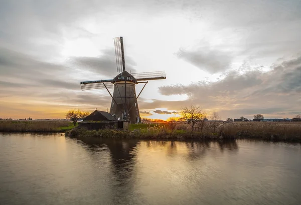 Wiatraki i kanały wodne o zachodzie słońca w Kinderdijk, Holandia. — Zdjęcie stockowe