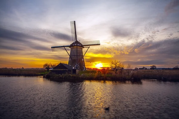 Wiatraki i kanały wodne o zachodzie słońca w Kinderdijk, Holandia. — Zdjęcie stockowe