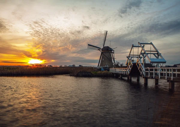 Wiatraki i kanały wodne o zachodzie słońca w Kinderdijk, Holandia. — Zdjęcie stockowe