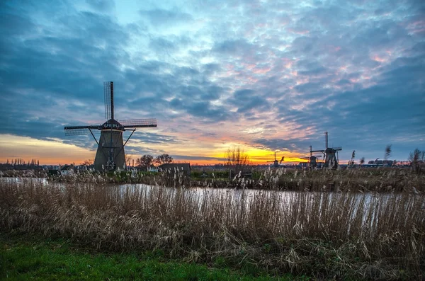 Moulins à vent et canal d'eau au coucher du soleil à Kinderdijk, Hollande. — Photo
