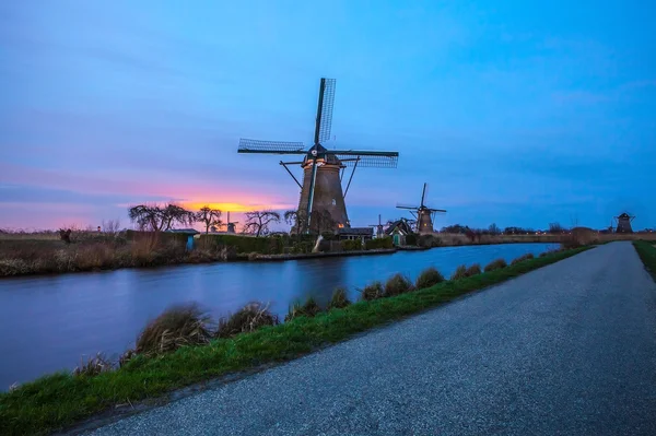 Mori de vânt și canal de apă la apus de soare în Kinderdijk, Olanda . — Fotografie, imagine de stoc