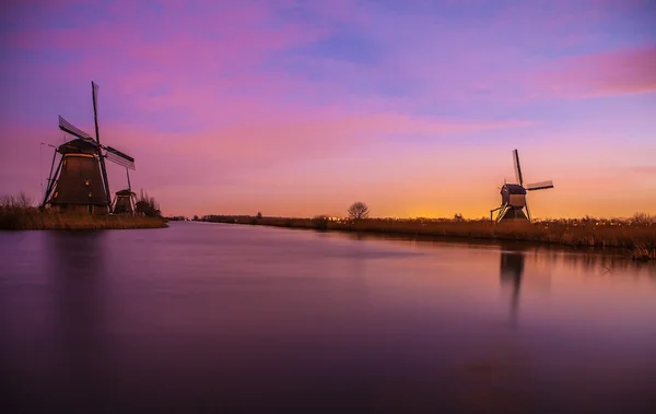 Wiatraki i kanały wodne o zachodzie słońca w Kinderdijk, Holandia. — Zdjęcie stockowe