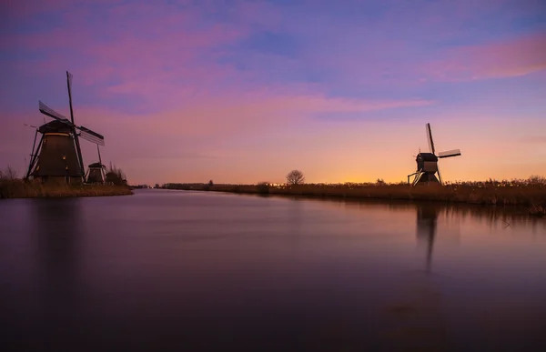 Wiatraki i kanały wodne o zachodzie słońca w Kinderdijk, Holandia. — Zdjęcie stockowe