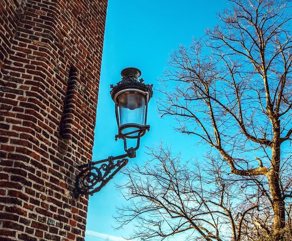 Ancien lampadaire sur le mur de construction . — Photo