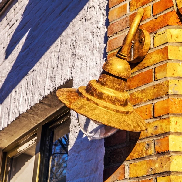 Ancien lampadaire sur le mur de construction . — Photo
