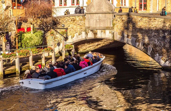 Brugge, Belgie - 17 ledna 2016: Přeprava lodí s turisty, které vypadají na starobylé budově středověkého města na 17 ledna 2016 v Brugge - Belgie. — Stock fotografie
