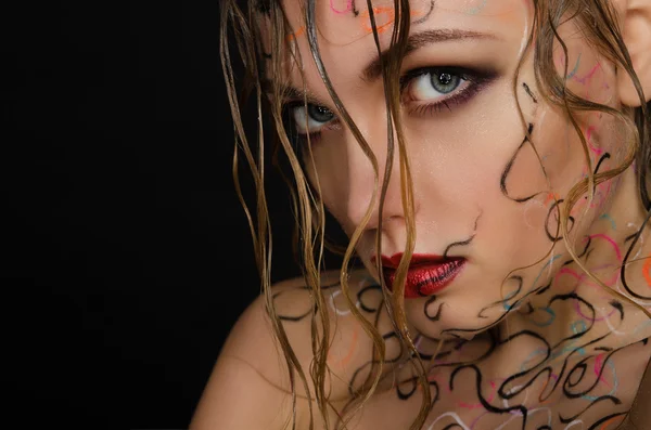 Schöne Frau mit nassen Haaren und Gesichtskunst — Stockfoto