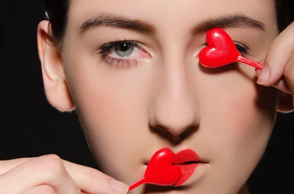 Jeune femme avec le cœur sur les lèvres et dans les yeux — Photo