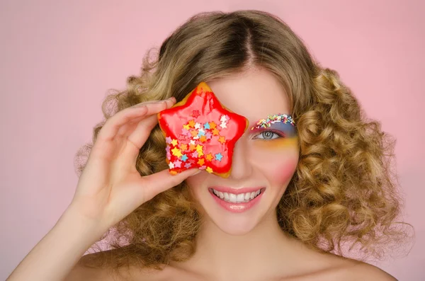 Lächelnde Frau mit Donut im Gesicht — Stockfoto