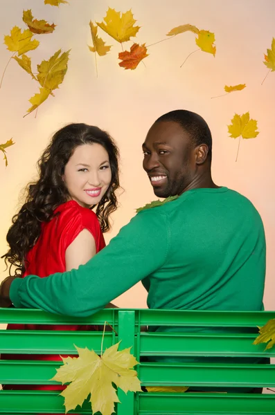 Fekete férfi és ázsiai nő a levelek alatt — Stock Fotó