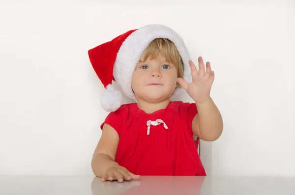 Happy little girl in costume of Santa at table — Stock Photo, Image
