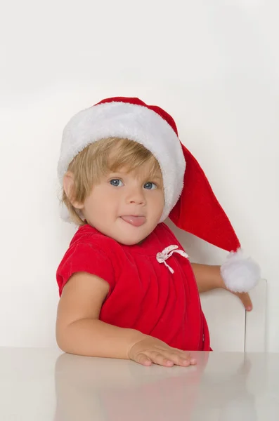 Criança vestida de Papai Noel à mesa — Fotografia de Stock