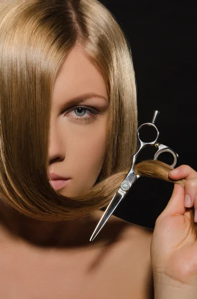 Jovem com cabelo liso segura tesoura — Fotografia de Stock