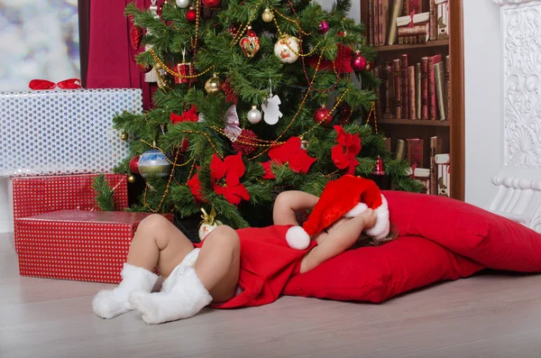 Small Santa is resting by Christmas tree — Stock Photo, Image