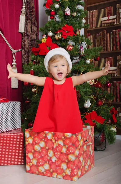 Smiling child dressed as Santa in box — Stock Photo, Image