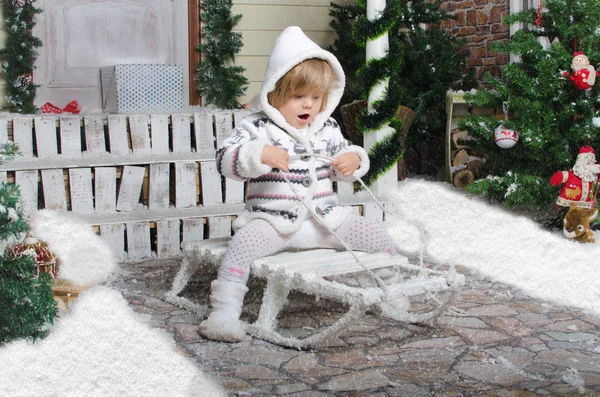 Niño en trineo en patio de nieve de invierno — Foto de Stock