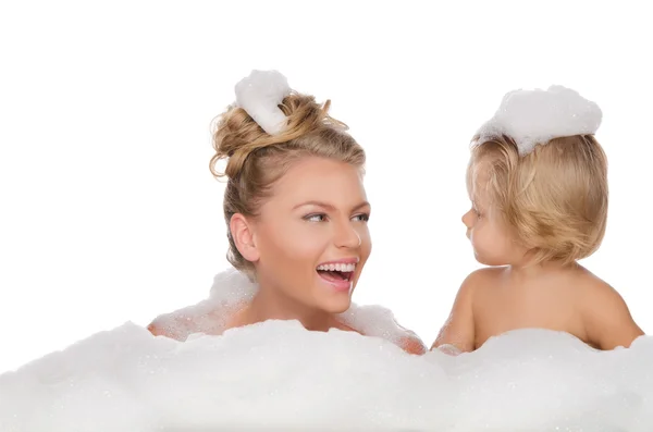 Lachende moeder met haar dochter en zeep schuim — Stockfoto
