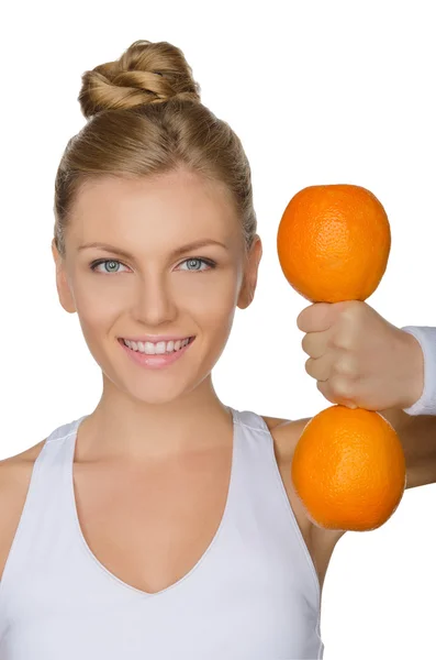 Belle femme avec haltères deux oranges mûres — Photo