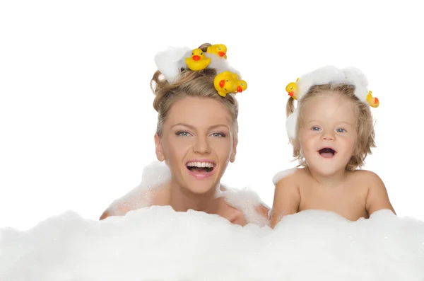 Joven madre, hija con patos y espuma de jabón — Foto de Stock