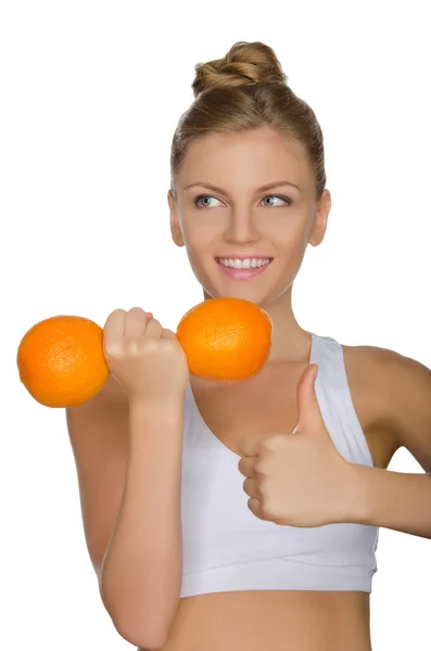 Happy woman with dumbbells fruits looking away — Stock Photo, Image