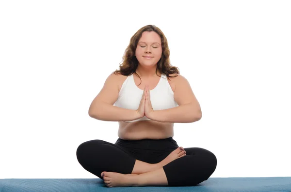 Donna con sovrappeso sta meditando sul tappeto — Foto Stock