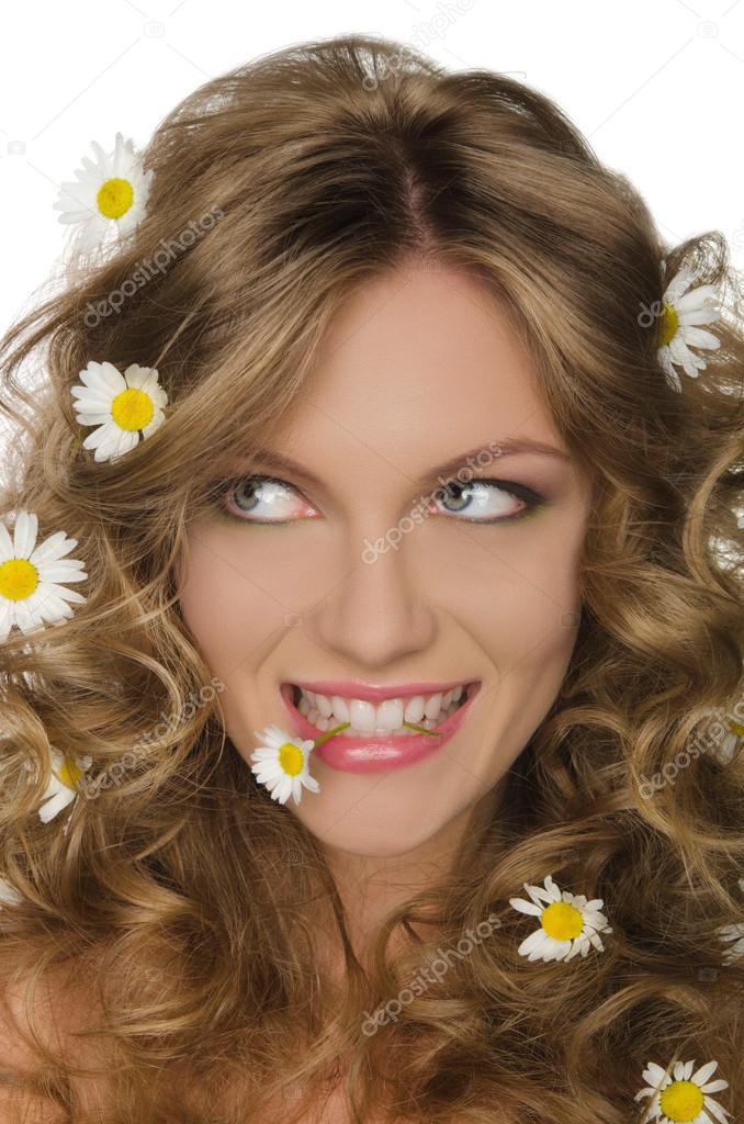 woman with daisies in hair and teeth, looking away