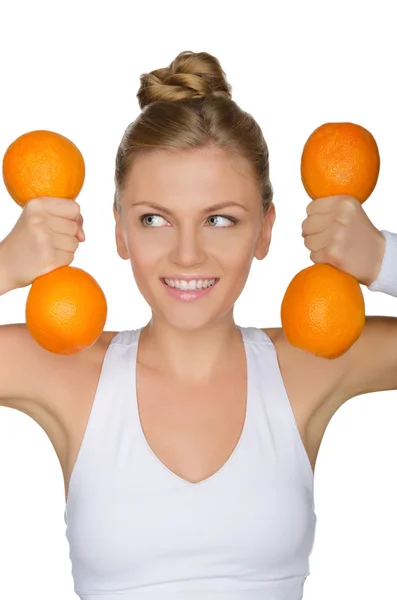 Woman with dumbbells from oranges looking away — Stock Photo, Image