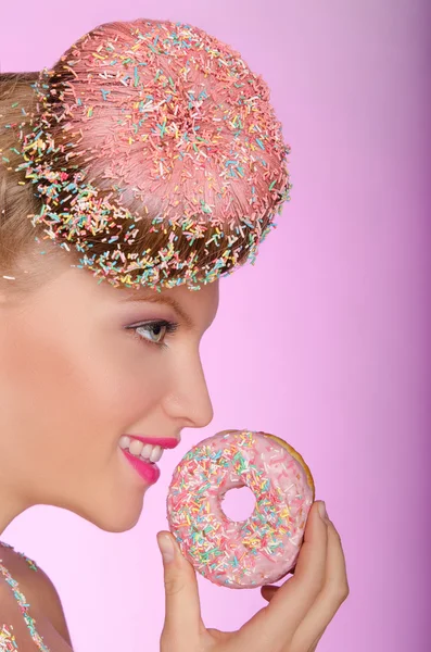 Mulher sorridente com donut na cabeça e na mão — Fotografia de Stock