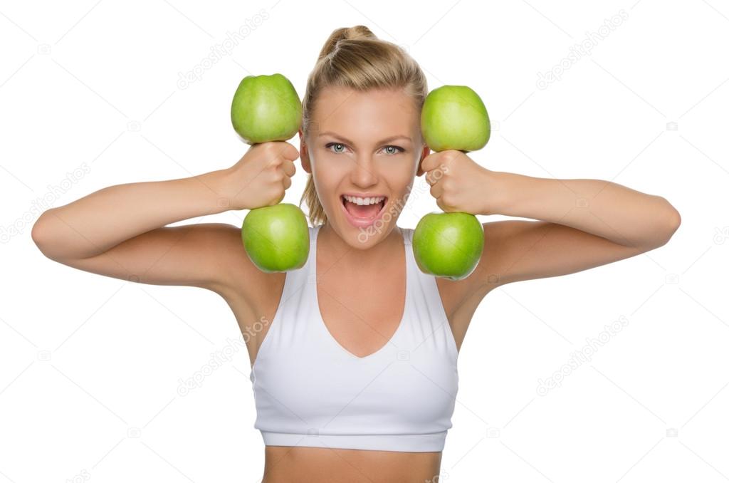 Beautiful woman with dumbbells from ripe apples