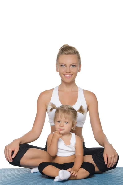 Mom and daughter doing yoga on mat — Stock Photo, Image