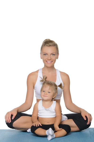 Anne ve kızı yoga mat yaparken gülümseyen