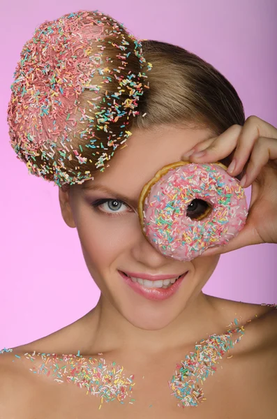 Jonge vrouw, donut op kop en voorzijde van het oog — Stockfoto
