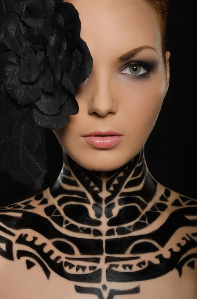Portrait of woman with flower and black body art — Stock Photo, Image