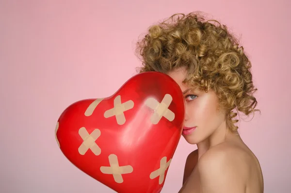 Distressed woman with ball in shape of heart — Stock Photo, Image