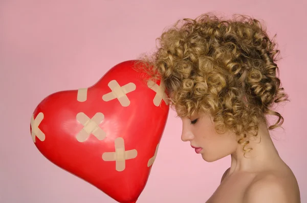 Mujer herida con bola en forma de corazón Fotos De Stock