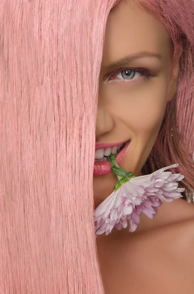 Mulher com cabelo rosa e flor em seus dentes — Fotografia de Stock