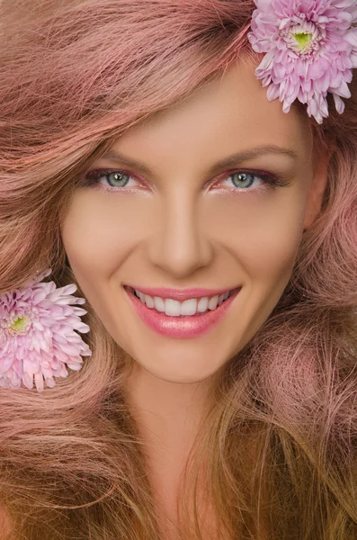 Schöne Frau mit rosa Haaren und Blumen — Stockfoto