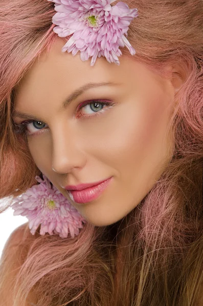 Schöne glückliche Frau mit rosa Haaren und Blumen Stockbild