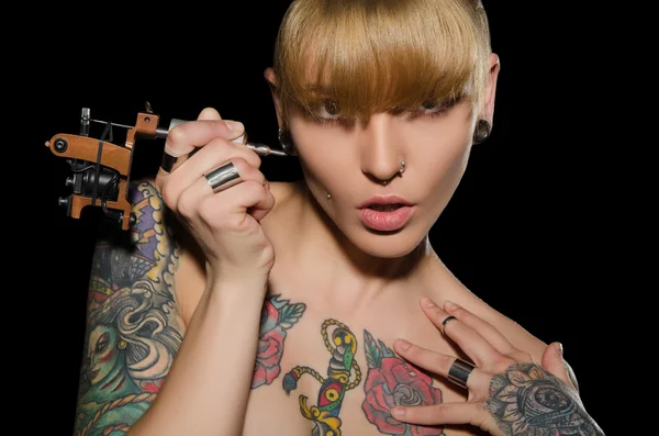 Молода блондинка з татуювальною машиною і для них — стокове фото