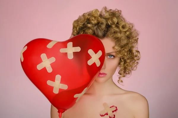 Upset woman with patches on the body and balloon — Stock Photo, Image