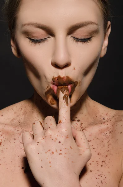 Sexig kvinna med choklad, finger i munnen — Stockfoto