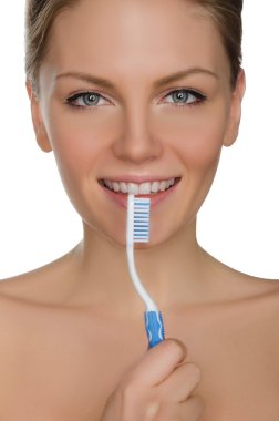 smiling woman with toothbrush in mouth