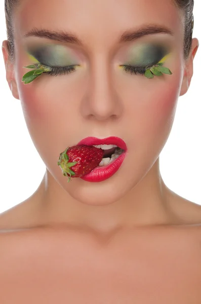 Face of young woman with strawberry in mouth — ストック写真