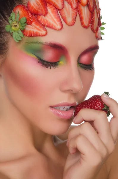 Young woman with strawberries on face and hand — Stockfoto