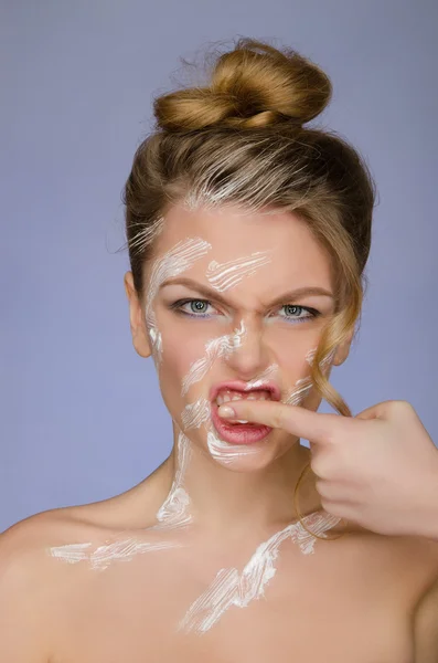 Woman in toothpaste on body cleans finger teeth — Stockfoto