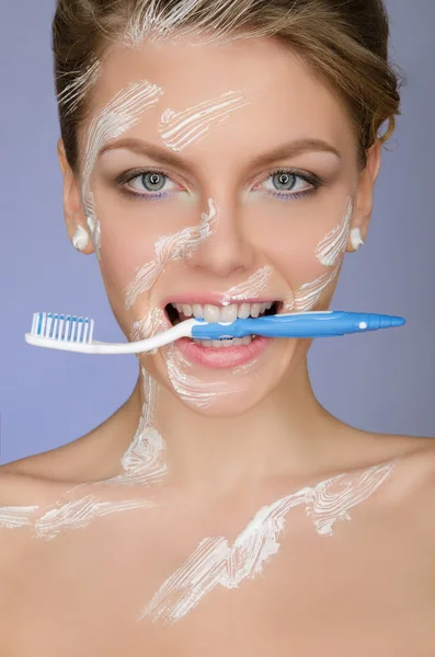 Woman with toothbrush mouth and in toothpaste — ストック写真