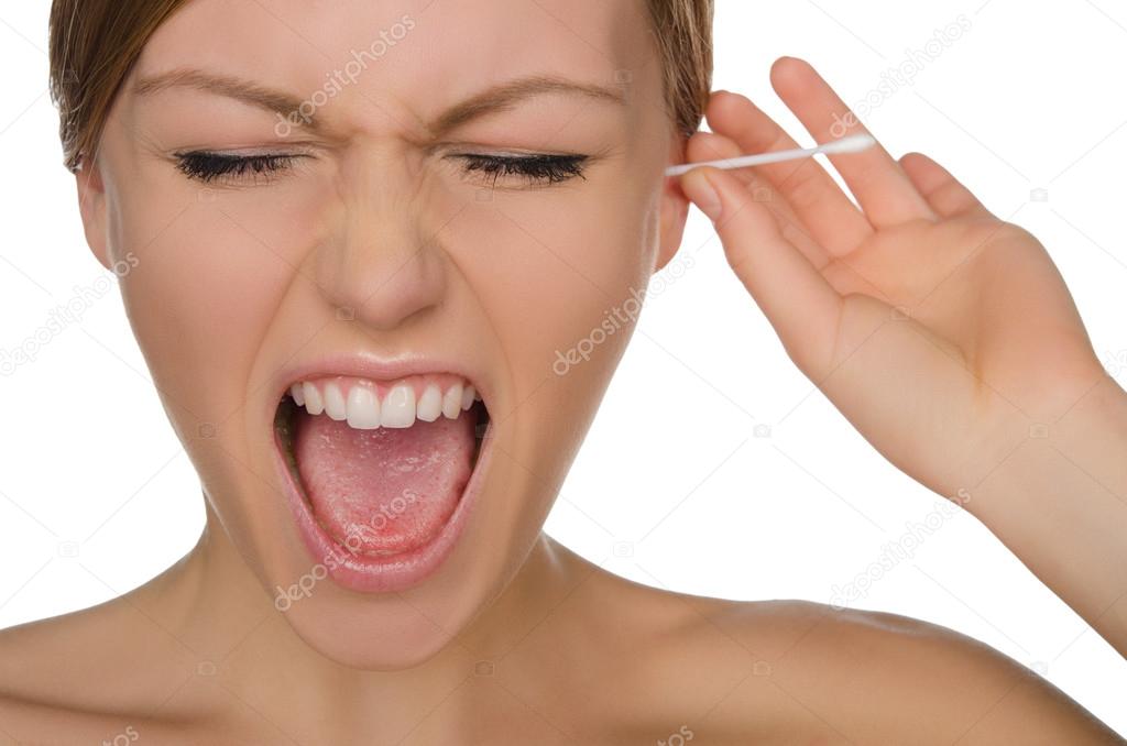 woman screams and cleans ears with cotton sticks