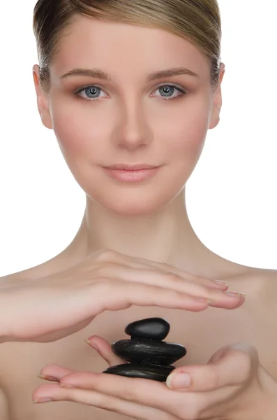 Beautiful woman holding black stones in hand — Stock Photo, Image