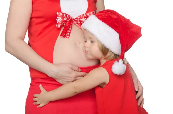 Child hugs belly of pregnant woman at Christmas — Stock Photo, Image